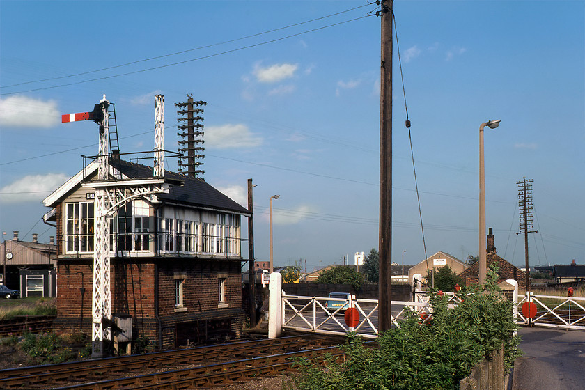 Sinsil Bank signal box (GE, 1882) & gates 
 For me, the star of this photograph is not the 1882 Great Northern signal box but the incredibly ornate twin doll bracket signal just in front of it. This is despite what appears to be the crass removal of the higher doll using what looks to be oxyacetylene? This scene is at Sinsal Bank just east of Lincoln's city centre where the appropriately named Great Northern Terrace crosses the Sleaford line. The layout is very similar today with all the land to the left occupied by Network Rail and indeed today the rather austere Lincoln Signalling Centre is built where the vehicle is parked in front of the former shed. Notice 31153 stabled at the head of a rake of stock just to the right of the box and the rare blue car that has just crossed the level crossing; when did you last see a Simca 1501 estate or even knew of its existence? 
 Keywords: Sinsil Bank signal box Great Eastern Railway GER