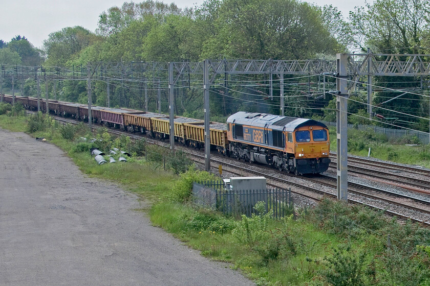 66777, 01.10 North Wembley Junction-Bescot (6G52, 7L), site of Roade station 
 A poorly composed picture down to a camera malfunction caused by the operator! I would not normally include it but for the fact that this particular Class 66 is a photographic cop. 66777 'Annette' leads the 6G52 10.10 North Wembley Junction to Bescot composed of a combination of JNA and MLA ballast wagons past the site of Roade station. The Class 66 is one of the low emission members of the class run by GBRf but I am unsure as to why it is named as such unless anybody can advise me? 
 Keywords: 66777 01.10 North Wembley Junction-Bescot 6G52 site of Roade station GBRf Annette