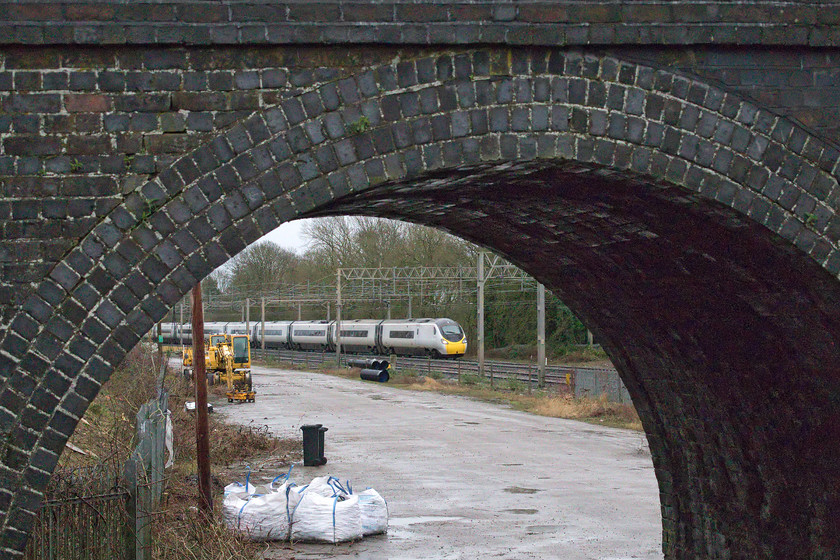 390008, VT 07.30 London Euston-Glasgow Central (1S42, 10L), site of Roade station 
 Unfortunately, when the Pendolinos were stripped of their Virgin identity following the end of their franchise during December 2019, 390008 'Charles Rennie Mackintosh' lost its unique handlebar moustaches on each nose cone. This vinyl always made this particular set easy to identify and was comedically typical of the approach that Virgin took towards their trains. It is seen passing the site of Roade station working the 1S42 07.30 Euston to Glasgow Central from a recently opened up spot that will be unusable soon when contractors finish work on the nearby housing estate. 
 Keywords: 390008 07.30 London Euston-Glasgow Central 1S42 site of Roade station Charles Rennie Mackintosh Avanti West Coast Pendolino