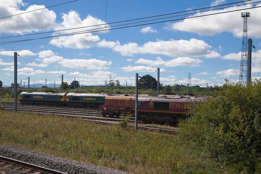 66510, 66509 & 66230, stabled, Kingmoor yard 
 With the hills of the Northern Lakes on the skyline our Pendolino home passes Kingmoor yard north of Carlisle. On view in this image are concurrently numbered Freightliner operated 66509 and 66510 along with 66230 in its EWS livery. 
 Keywords: 66510 66509 66230 Kingmoor yard