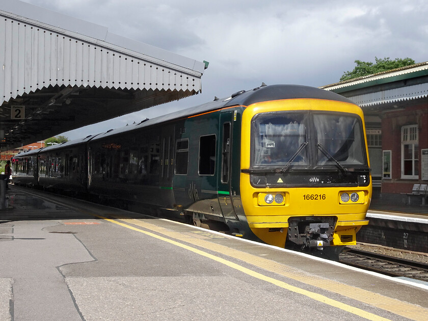 166216, GW 14.10 Gloucester-Frome (2C17, RT), Westbury station 
 166216 leaves Westbury station working the 14.10 Gloucester to Frome service. Since being cascaded from the Thames Valley these turbo units have become the mainstay of operations around the Bristol area. Whilst they look smart in their GWR livery there is no disguising that they are now over thirty years old. 
 Keywords: 166216 14.10 Gloucester-Frome 2C17 Westbury station