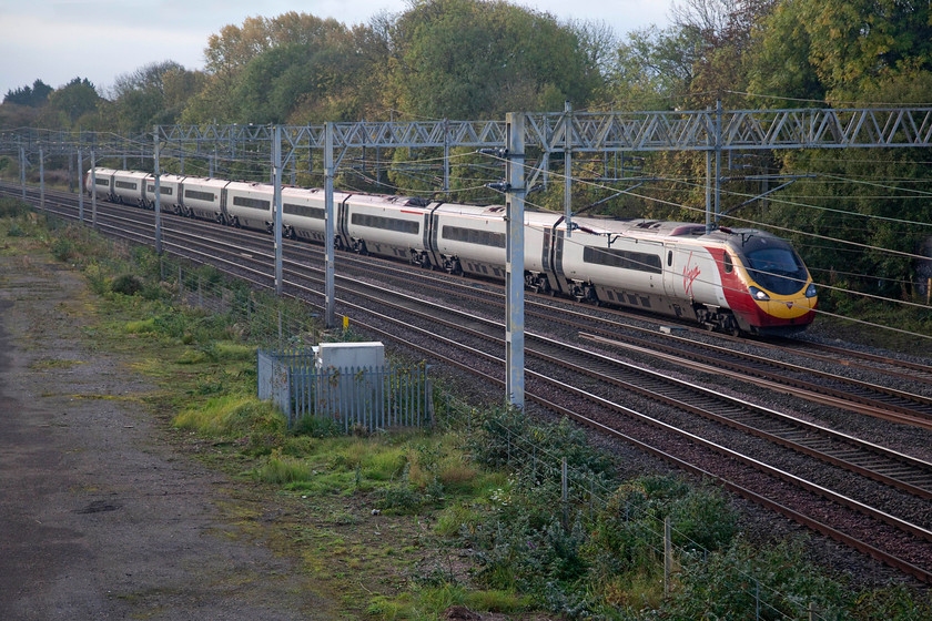 390043, VT 07.23 London Euston-Birmingham New Street (9G05, 11L), site of Roade station 
 390043 passes the site of Roade station and just catches some early morning rays of sunshine. It is working the 9G05 07.23 London Euston to Birmingham New Street. 
 Keywords: 390043 07.23 London Euston-Birmingham New Street 9G05 site of Roade station