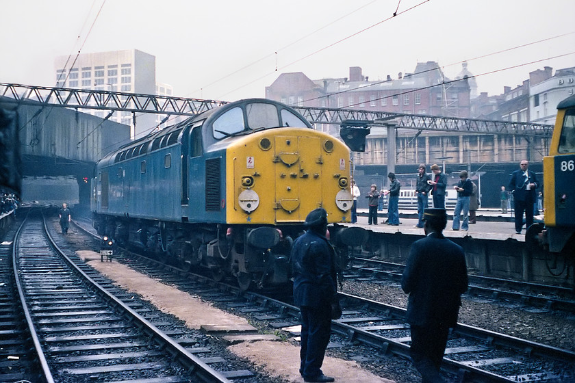 40024, LE for the outward leg of the Pennine Explorer, Cardiff Central-Rotherwood, Birmingham New Street station 
 40024 passes through the centre road at Birmingham New Street station ready to join the back of the Pennine Explorer railtour. It will lead the railtour on the second leg as far as Manchester Piccadilly. Notice the total absence of any H & S workwear for the three staff working at track-level. Unfortunately, I do not have a record of the 86 poking its nose into the right of the picture, the only two I have in my notebook are 86101 and 86243 so, it's one of those! 
 Keywords: 40024 Pennine Explorer Cardiff Central-Rotherwood Birmingham New Street station