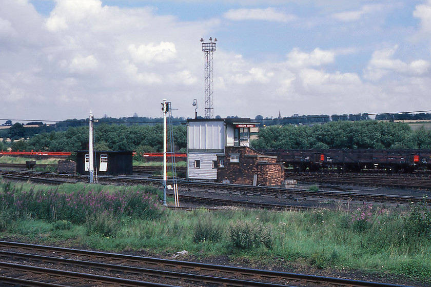 Neilson Sidings Signal Box (BR, c.1965) 
 This is the nearest that Graham and I could get to Neilson Sidings signal box (as opposed to Neilson's Sidings) and even then we received a tirade of verbal abuse from the owner of the yard into which we had ventured to get the photograph. It is a British Railways (London Midland Region) Type 15 design fitted with a twenty lever London Midland Region standard frame and controlled the complex signalling and points within the yard that still exists today but that is mainly used by stone and infrastructure trains. Both boxes are named after a local farmer and landowner Walter Neilson who owned much of the land stretching out in the distance. He developed his land by mining iron ore and close to the surface and built a network of narrow gauge routes to get the ore to the mainline in this yard and also directly into the ironworks that was located where I am standing. Notice the spire of the fourteenth century St Mary the Virgin church in Finedon on the skyline. The current reverend is the well-known broadcaster and former Communards band member Richard Coles.