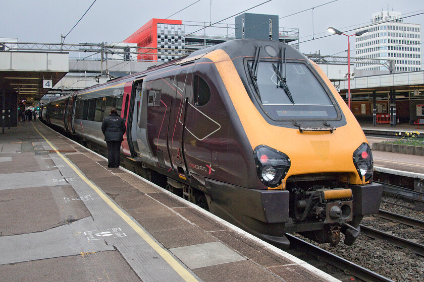 220021 XC 14.57 Bournemouth-Manchester Piccadilly (1M62, RT), Coventry station 
 On arrival at Coventry station after our journey from Oxford the rear of our train, the 14.57 Bournemouth to Manchester Piccadilly is seen waiting to depart. Notice the guard waiting to give the RA to the driver wrapped up in her XC issued coat protecting against the unseasonally cold wind. In fact, it had actually been snowing on our journey and on arrival back in Northampton there was an inch of lying snow, so much for springtime! 
 Keywords: 220021 14.57 Bournemouth-Manchester Piccadilly 1M62 Coventry station CrossCountry Voyager 220033