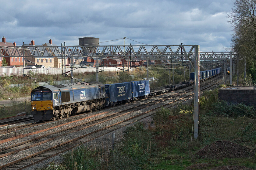 66429, 10.02 Tilbury-DIRFT (4M07, 12E), site of Roade station 
 The 4M07 DRS operated 10.02 Tilbury docks to Daventry (DIRFT) Tesco service approaches the site of Roade's former station with 66429 leading. This is a 'go-to' spot for afternoon photography summer or winter offering wide and unrestricted views of the line looking south but if the subject is on the slow line, as is the case here, then the risk of being bowled is ever-present. With the Pendolino seen in the background approaching very fast I just avoided missing out by a few seconds on this occasion! 
 Keywords: 66429 10.02 Tilbury-DIRFT 4M07 site of Roade station DRS Direct Rail Services