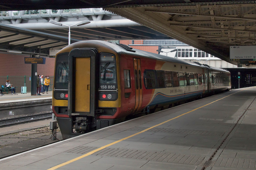 158858, EM 08.56 Norwich-Liverpool Lime Street (1R74, 1E), Nottingham station 
 158858 leaves Nottingham station working the 1R74 08.56 Norwich to Liverpool service. Notice the new bridge above the train and the station canopy. This was one of only two constructed as part of Nottingham Express Transit's (NET's) second phase of expansion. The bridge was opened in October 2014 and also is home to NET's interchange station that did seem a little exposed to the elements. Fine on a day like today but on a windy, wet and cold winter's day it would not be quite such a nice place to wait for a tram. So it is lucky that their service intervals are pretty short! 
 Keywords: 158858 EMR 08.56 Norwich-Liverpool Lime Street 1R74 Nottingham station East Midlands Railway Express Sprinter