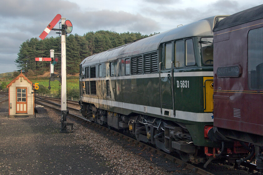 D5631, 15.55 Holt-Sheringham, Weybourne station 
 D5631 (formally 31207) gets slowly away from Weybourne station working the 15.55 Holt to Sheringham service. It is just passing a fine example of a GN somersault signal that is one of a number in use on the heritage line. Notice that some wag has chalked 'Scotland' on the panel of the BR Covered Carriage Truck (CCT) E94464! 
 Keywords: D5631 15.55 Holt-Sheringham Weybourne station 31207 A1A A1A Class 31 Type 2