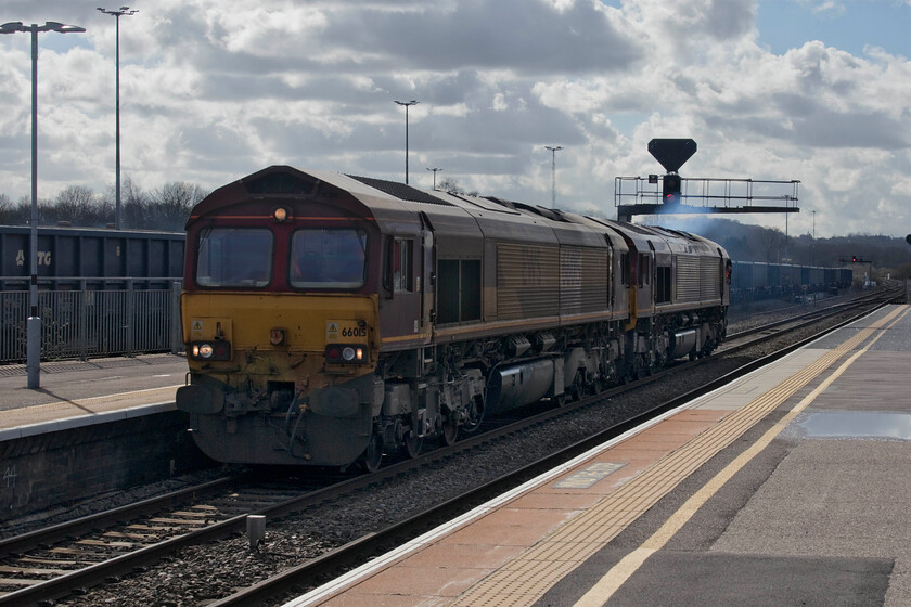 66015 & 66089, light engine move, Westbury station 
 With the second locomotive displaying some blue exhaust from its engine 66015 and 66089 accelerate through Westbury station heading off east. With nothing appearing on RTT I have been unable to identify where this pair of EWS liveried Class 66s were heading. Unfortunately, this was a bit of a grab shot into the sun as my next train home was arriving at platform three out of sight to the right. 
 Keywords: 66015 66089 light engine Westbury station