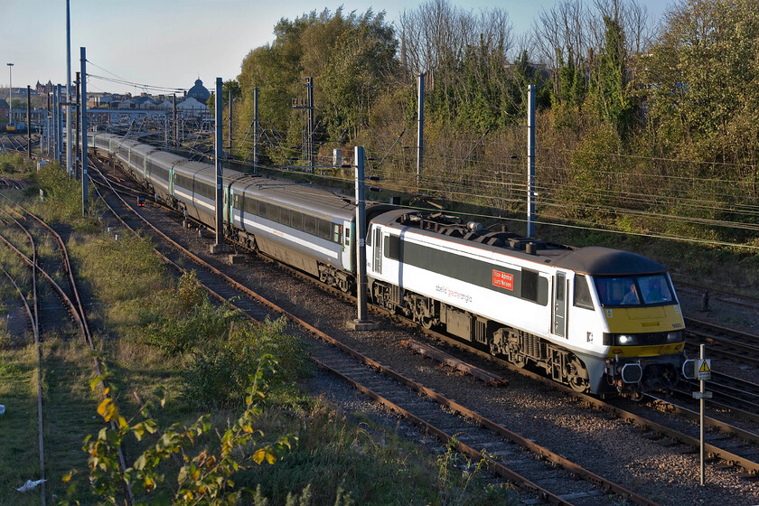 90005, LE 15.30 Norwich-London Liverpool Street (1P49), Thorpe Junction 
 90005 'Vice-Admiral Lord Nelson' winds the 15.30 Norwich to Liverpool Street service away from its starting point. It will not pick up much speed at this point as the train has to observe a forty miles per hour speed restriction a short distance away under the bridge I'm standing on as it crosses Wensum swing bridge. With the clocks having gone yesterday by this time in the afternoon the sun is already getting very low in the sky but it does produce a lovely quality of light. 
 Keywords: 'Vice-Admiral Lord Nelson' 90005 15.30 Norwich-London Liverpool Street 1P49 Thorpe JunctionAbellio Greater Anglia