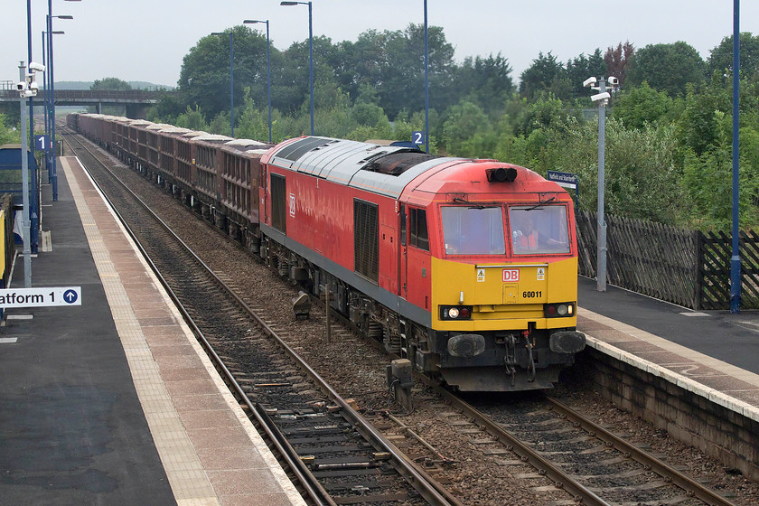 60011, 11.38 Redcar B.S.C.-Scunthorpe Trent (6N11), Hatfield & Stainforth station 
 Contrary to what you might believe from this photograph, 60011 is in fact at walking pace just restarting the incredibly heavy 6N11 11.38 Redcar to Scunthorpe Trent flyash train. The train had come to a halt, with the wagons straddling Stainforth Junction in the distance, for a driver to alight from the cab and get into a taxi that was waiting in the station carpark. The relief driver then did a skilled job with the three thousand one hundred bhp available to him to get the train moving. This type of train is exactly what a class 60 was designed for, and one that they operate with no fuss despite coming up for thirty years old. 
 Keywords: 60011 11.38 Redcar B.S.C.-Scunthorpe Trent 6N11 Hatfield & St