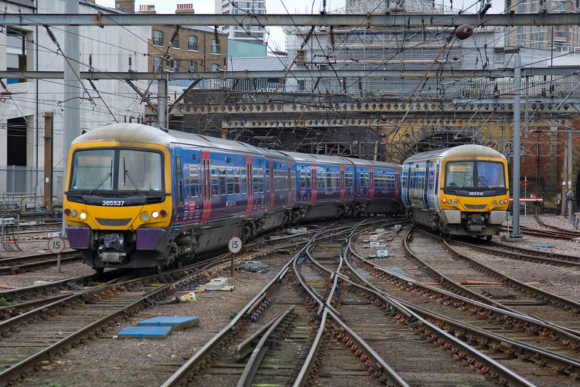 365537, FC 07.46 Peterborough-London King's Cross (1P49) & 365510, FC 09.08 London King's Cross-Peterborough (1P46), London King's Cross station 
 A coming together of Class 365s at King's Cross station. To the left and operated by First Capital Connect 365537 arrives with the 1P49 07.46 from Peterborough. To the left 365510 is being operated by Great Northern and is leaving with the 09.08 to Peterborough. Two identical units operating on the same route between the same station and yet operated by two different operators.....our privatised railway at its very best I'd say! 
 Keywords: 365537 07.46 Peterborough-London King's Cross 1P49 365510 09.08 London King's Cross-Peterborough (1P46), London King's Cross station