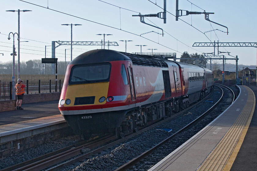 43320 EM 05.19 Leeds-London St. Pancras (1C15, RT), Wellingborough station 
 After being in operation on the MML for some thirty-eight years the fabled HSTs are about to bow out as electric services commence on the Corby to St. Pancras route. This 'cascade' will allow the HSTs to be put into short term storage and then be sent to the breaker's yard. Attracting the attention of a Royal Mail worker 43320 leaves Wellingborough station at the rear of the 1C15 05.19 Leeds to St. Pancras service. 
 Keywords: 43320 05.19 Leeds-London St. Pancras 1C15 Wellingborough station EMR East Midlands Railway HST