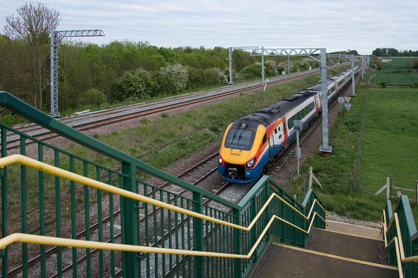 222003, EM 18.02 London St. Pancras-Sheffield (1F60, 31L), Irchester SP927667 
 This photograph is taken from the huge new bridge installed a couple of years ago that carries a footpath over the line at Irchester. It's not one of Network Rail's most attractive structures but it does offer some new views of the MML at this location between Wellingborough and Bedford. 222003 and another unidentified Meridian is descending from Sharnbrook summit forming the 18.02 St. Pancras to Sheffield. There were issues between Kettering and Leicester as all trains were heavily delayed, with this one arriving thirty-one minutes late. 
 Keywords: 222003 18.02 London St. Pancras-Sheffield 1F60 Irchester SP927667