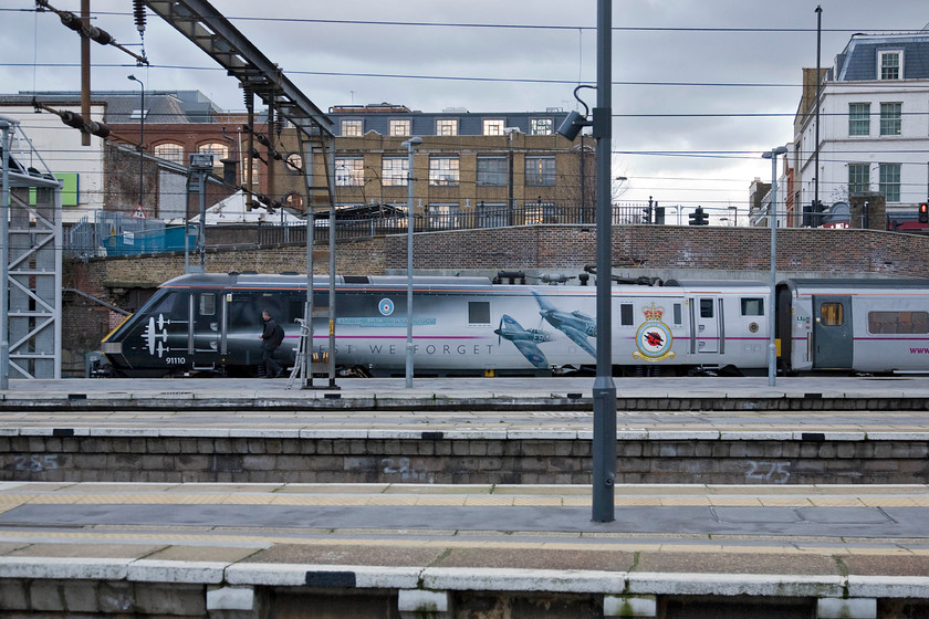 91110, GR 17.30 London King's Cross-Newcastle, (1N27), London KIng's Cross station 
 The driver of the 1N27 17.30 to Newcastle walks to his cab in readiness to prepare the locomotive for its departure in the next half an hour. His locomotive is one of East Coast's celebrity Class 91s 91110 'Battle of Britain Memorial Flight' that looks superb wearing its vinyls created and applied by the market leader in these products, Stewart Signs Ltd of Chandlers Ford. As well as wearing this impressive livery, 91110 also holds the national speed record for an electric locomotive of one hundred and sixty-two miles per hour attained at Stoke Bank on 17th September 1989. 
 Keywords: 91110 17.30 London King's Cross-Newcastle 1N27 London KIng's Cross station Battle of Britain Memorial Flight