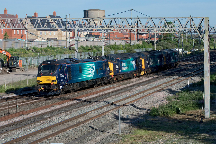 88002, 37059, 37716 & 37069, 12.44 Eastleigh-Crewe Gresty Bridge (0Z69, 219E), site of Roade station 
 A sea of DRS blue at Roade! This four locomotive move started off with 37716 and 37069 (the rear two locomotives) running up from Eastleigh to Willesden Yard. Here they teamed up with 88002 and 37059 (the front two) with the whole lot heading north as the 0Z69 to DRS' Crewe Gresty Bridge facility. They look very smart in the early evening sun but, unfortunately, the rear two have not quite made it into the light. 
NB - The following day the whole combo moved again from Crewe to DRS at Carlisle. 
 Keywords: 88002 37059 37716 37069 12.44 Eastleigh-Crewe Gresty Bridge 0Z69 site of Roade station Prometheus DRS Direct Rail Services