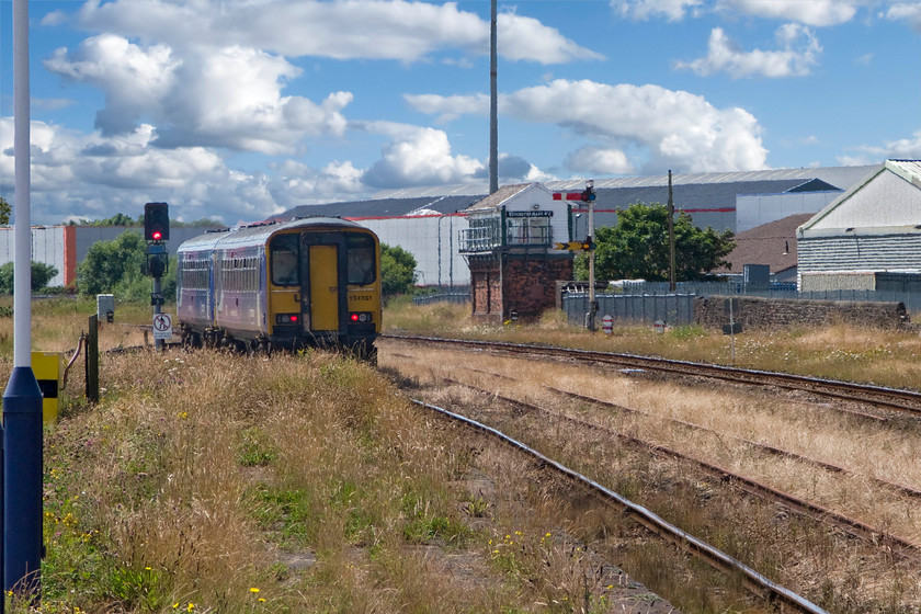 153330, NT 12.08 Carlisle-Barrow-in-Furness (2C48), Workington station 
 153330 leaves Workington station as the 2C48 12.08 Carlise to Barrow-in-Furness. It looks as though the train is travelling through a field given the totally uncontrolled vegetation growth as permitted by Network Rail that is somewhat yellower than normal given the dry summer; what a mess! Through the heat haze in the background is the fifty-eight lever Workington Main No. 2 signal box constructed in 1886 by the London and North Western Railway. 
 Keywords: 153330 12.08 Carlisle-Barrow-in-Furness 2C48 Workington station Northern Trains