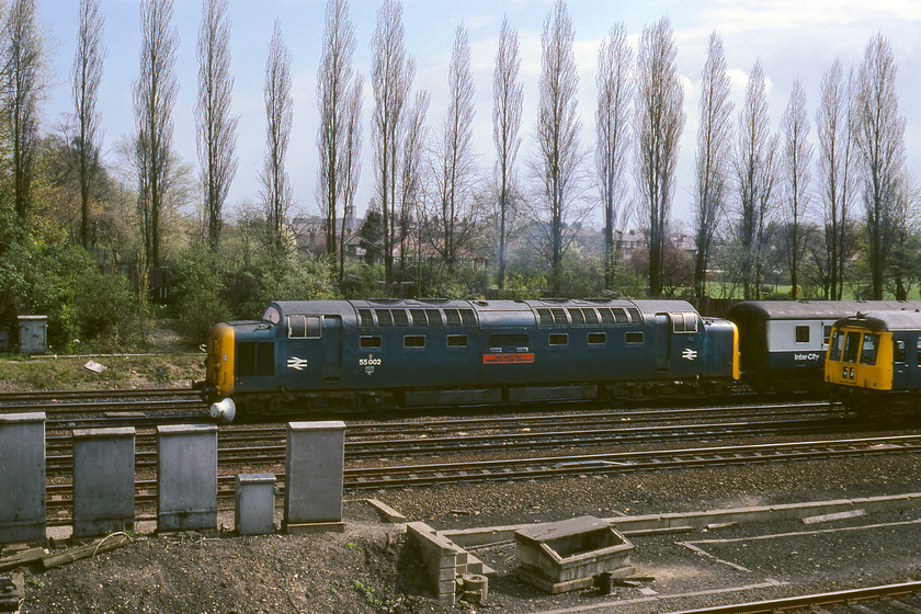 55002, 12.20 London King's Cross-York (1L42) & Class 104 DMU, Holgate bridge 
 Almost completing its 188-mile journey, 55002 'The King's Own Yorkshire Light Infantry' approaches York leading the 12.20 1L42 from King's Cross. This broadside view taken at Holgate bridge really shows off the elegant shape and bulk of the Deltic. Just to the right of the photograph, a Class 104 DMU is also approaching the station with a service from the Leeds area. The land behind the tall poplar trees belongs to The Mount School, a Quaker independent day and boarding school for children of all ages. 55002 is preserved today and in working order again, being part of the National collection. After languishing at The National Railway Museum for many years, the Friends of 55002 KOYLI got it operational and haulage behind this fine locomotive can be enjoyed today on various preserved lines. 
 Keywords: 55002 12.20 London King's Cross-York 1L42 Class 104 DMU Holgate bridge The King's Own Yorkshire Light Infantry