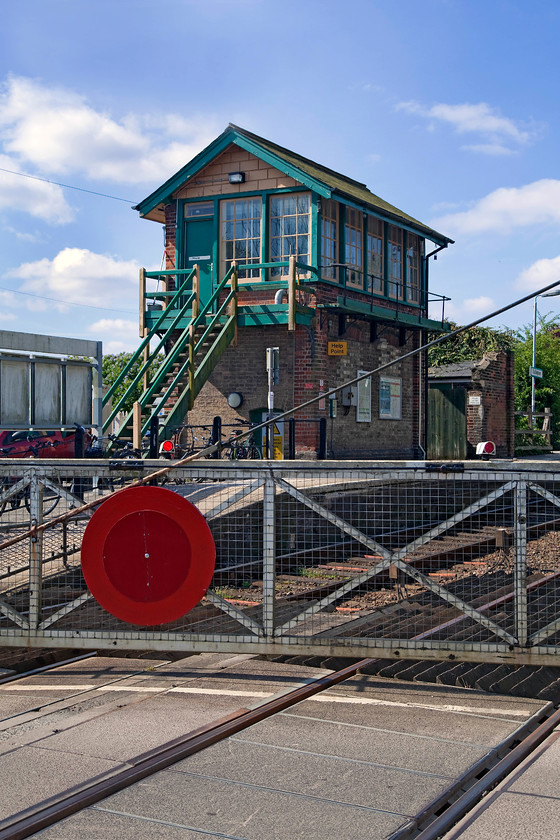 Dullingham signal box & crossing gate (GE, 1883) 
 The impressive and smart looking Dullingham signal box is on a tiny remaining section of token and absolute block line remaining in this area. The signal box is a Great Eastern structure dating from 1883 where the signalman still leaves the box to operate the level crossing gates manually. Despite Dullingham having two tracks, as seen in the picture, one is only a rarely used passing loop. The track to the left is the main running line for both up and down trains. 
 Keywords: Dullingham signal box crossing gates