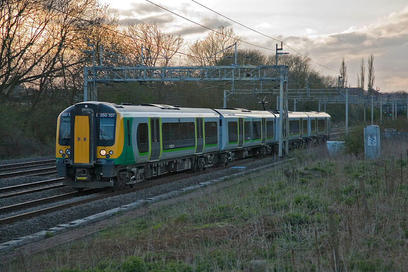 350107, LM 18.41 Birmingham New Street-London Euston, Roade 
 350107 passes Roade working London Midland's 18.41 Birmingham New Street to Euston service. The evening sunshine is still proving troublesome but I have chosen to photograph the train from the wrong side! 
 Keywords: 350107 18.41 Birmingham New Street-London Euston Roade London Midland desiro