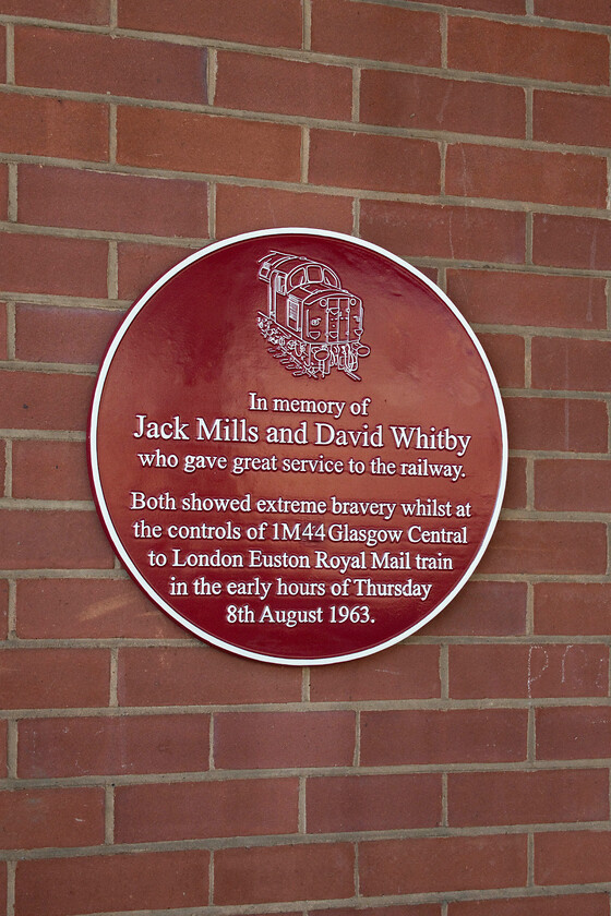 Plaque, Crewe station 
 I have never noticed this red plaque on Crewe station's platform twelve so I am not at all sure if it has recently been unveiled? It commemorates the bravery shown by the driver and second man of the 1M44 that was stopped and robbed by a ruthless gang of thugs in the summer of 1963 at Bridego bridge just north of Cheddington. Both men received dreadful injuries with Jack Mills later dying from these after never being able to work again. For this reason, I fail to understand how in popular culture the thieves have become some sort of heroes who beat the establishment and how I also resent the whole event being referred to as the 'great' train robbery, great it certainly was not. 
 Keywords: Plaque Crewe station