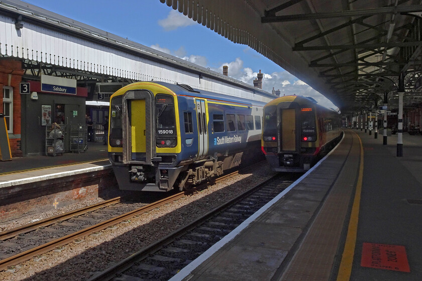 159018, SW 12.25 Exeter St. David's-London Waterloo (Cancelled from Basingstoke) (1L48, RT) & 159885, SW 13.08 Romsey-Salisbury (2S35, 4L), Salisbury station 
 159018 catches the sun at Salisbury station working at the rear of the 12.25 Exeter to Waterloo service. Meanwhile, 159885 is in the shade having just terminated with the 2S35 local from Romsey. I have been to Salisbury station many times since my early spotting days and have always found it busy and interesting but the diversity of traction is not quite the same from when I visited in 1981, see.... https://www.ontheupfast.com/p/21936chg/C385496854/x14-day-trip-to-salisbury-08-08-81 
 Keywords: 159018 12.25 Exeter St. David's-London Waterloo Cancelled from Basingstoke 1L48 159885 13.08 Romsey-Salisbury 2S35 Salisbury station SWT