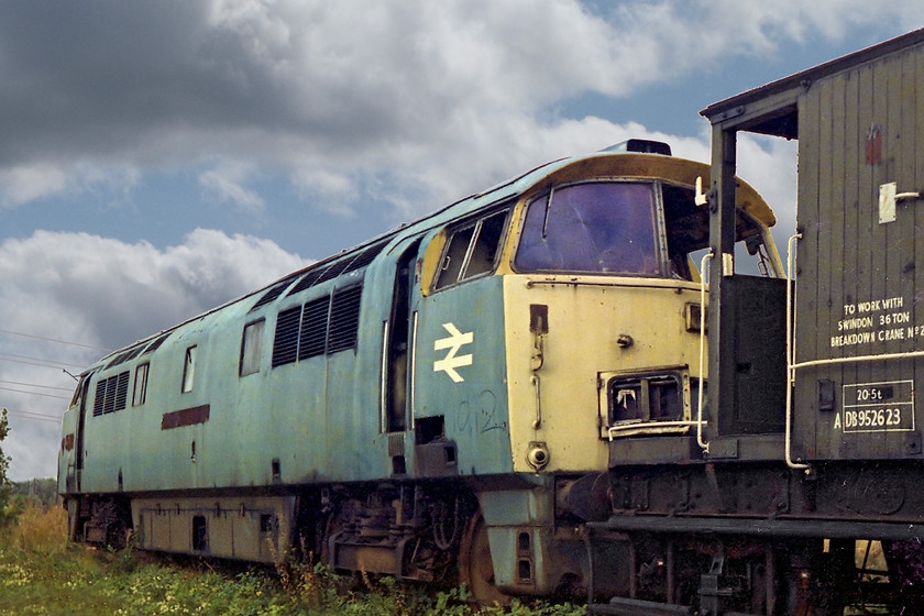 D1012, scrap line, Swindon Works 
 Having been on the Swindon scrap-lines for 3 years, D1012 'Western Firebrand' is looking very faded and forlorn. The brake van will be another casualty of the cutter sooner than later!