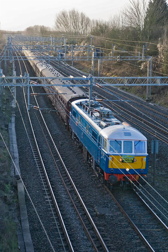 86259, outward leg of The Winter Cumbrian Mountain Express, 07.20 London Euston-Carlisle (1Z86), Victoria bridge 
 If the 1Z86 Cumbrian Mountain Express had been travelling on its normal route using the fast line (to the extreme right in this photograph) it would be catching the early morning sunshine. Unfortunately, due to a reported track fault on the Weedon line the charter from Euston to Carnforth for steam (45699 'Galatea') had to be diverted via Northampton. Led by 86259 'Les Ross/Peter Pan' is seen approaching Victoria bridge on the approach to Roade. 
 Keywords: 86259 The Winter Cumbrian Mountain Express 07.20 London Euston-Carlisle 1Z86 Victoria bridge Les Ross Peter Pan WCR