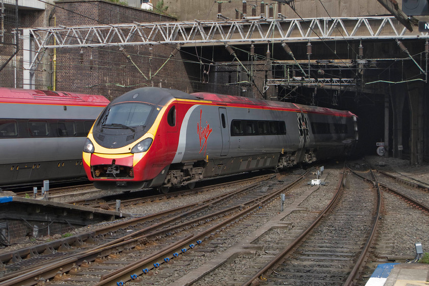 390039, VT, 14.43 London Euston-Edinburgh (9S80), Birmingham New Street station 
 So many Pendolinos travel with their nose cone covers either open or, as in this case, partially open thus exposing the Dellner 12 coupling mechanism. I am sure that this does nothing for the aerodynamics of the power cars as well as offering no protection to the innards itself! 390039 enters Birmingham New Street working the 14.43 Euston to Edinburgh Waverley as one of its cousins leaves to the left. 
 Keywords: 390039 14.43 London Euston-Edinburgh 9S80 Birmingham New Street station Pendolino Voyager