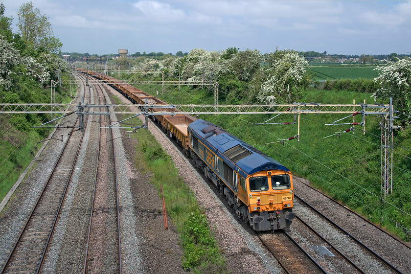 66728, 23.33 North Wembley Junction-Bescot (6G51, 30E), Victoria bridge 
 Dead in tow at the rear of the 6G51 23.33 North Wembley Junction to Bescot infrastructure train is 66728 'Institution of Railway Operators'. At the front of the train, which is composed almost entirely of a long rake of JNA wagons, is 66714 'Cromer Lifeboat'. With the sun getting to work burning back the cloud drifting in from the east the train is seen approaching Roade from Victoria bridge. 
 Keywords: 66728 23.33 North Wembley Junction-Bescot 6G51 Victoria bridge Institution of Railway Operators