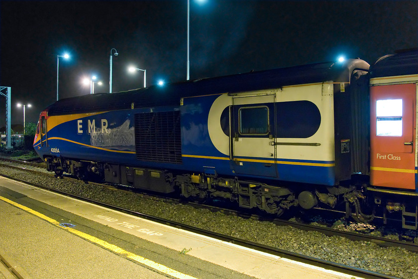 43054, EM 18.34 London St. Pancras-Leeds (1D64, 12L), Wellingborough station 
 Looking very smart and complete with its new EMR branding, HST power car 43054 pauses at Wellingborough station on the rear of the 18.34 St. Pancras to Leeds. In this image, it looks as if I need to straighten it up in Photoshop but the datum points of the lamp posts and electrification mast tells me that it is level. The power car looks tipped as the camber of the track at Wellinborough's platform one is quite harsh, a situation that creates a huge and alarming drop between the train and the platform edge. 
 Keywords: 43054 HST 18.34 London St. Pancras-Leeds 1D64 Wellingborough station HST