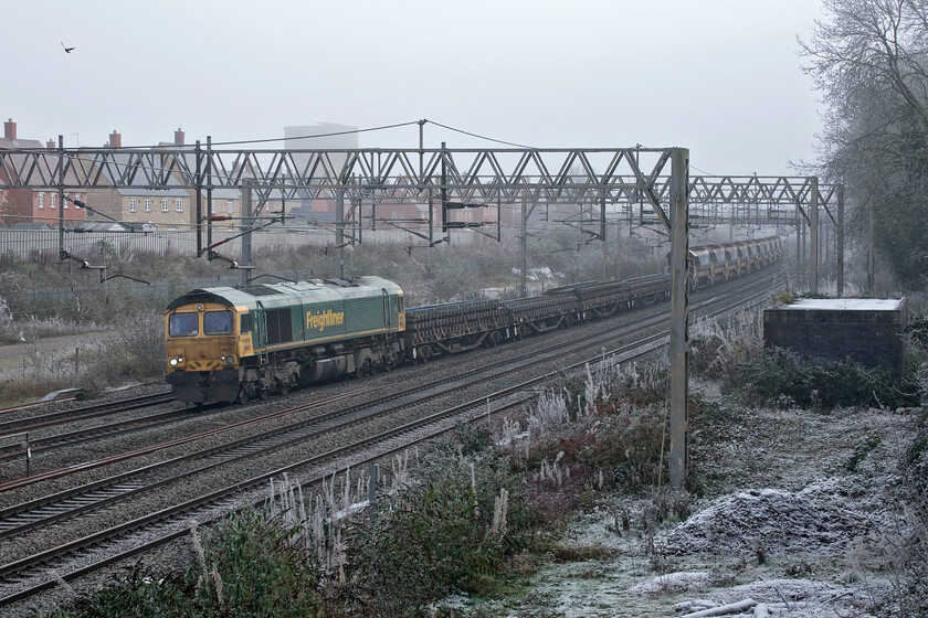 66951, 11.33 Hanslope Junction-Bescot Yard (6Y61, 9L), site of Roade station 
 Running rather late after missing its scheduled departure time from the down slow just south of Hanslope Junction the 6Y61 11.33 infrastructure working to Bescot Yard ambles past a frosty and foggy Roade. The rake of YWA Salmon bogie flat wagons and HQAH bogie autoballasters is being hauled by Freightliner's 66951 with 66554 out of sight on the rear. After its late start, the train gained some of its time arriving just nine minutes behind schedule at Bescot. 
 Keywords: 66951 11.33 Hanslope Junction-Bescot Yard 6Y61 site of Roade station Freightliner