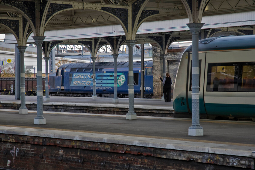 37604, stabled & class 170, LE 16.38 Norwich-Cambridge (2K85), Norwich station 
 In very low lighting use and exposure of 1/15 of a second 37604 is glimpsed at the far side of Norwich station awaiting its next trip to the seaside possibly tomorrow? meanwhile, an unidentified Class 170 unit is waiting for the guard's whistle to depart with the 16.30 local to Cambridge. 
 Keywords: 37604 class 170 16.38 Norwich-Cambridge 2K85 Norwich station