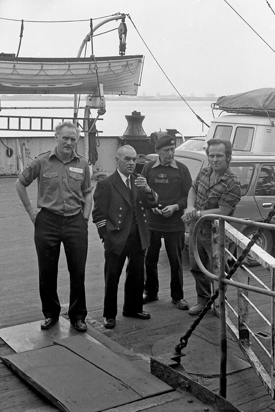 Crew members, MV Farringford 
 Crew members stand on the MV Farringford taking a short break prior to the continued loading for the 15.15 sailing from New Holland to Hull Corporation Pier. The Sealink brand is clear to see on the sweater worn by one of the crew members. Sealink operated the ferry service that crossed the Humber estuary. Unfortunately, within a week of this photograph being taken all four of the crew will loose their jobs with the cli]osure of the route with the opening of the Humber bridge; I hope that their redundancy package was consummate with their time in service. 
 Keywords: Crew members MV Farringford Sealink