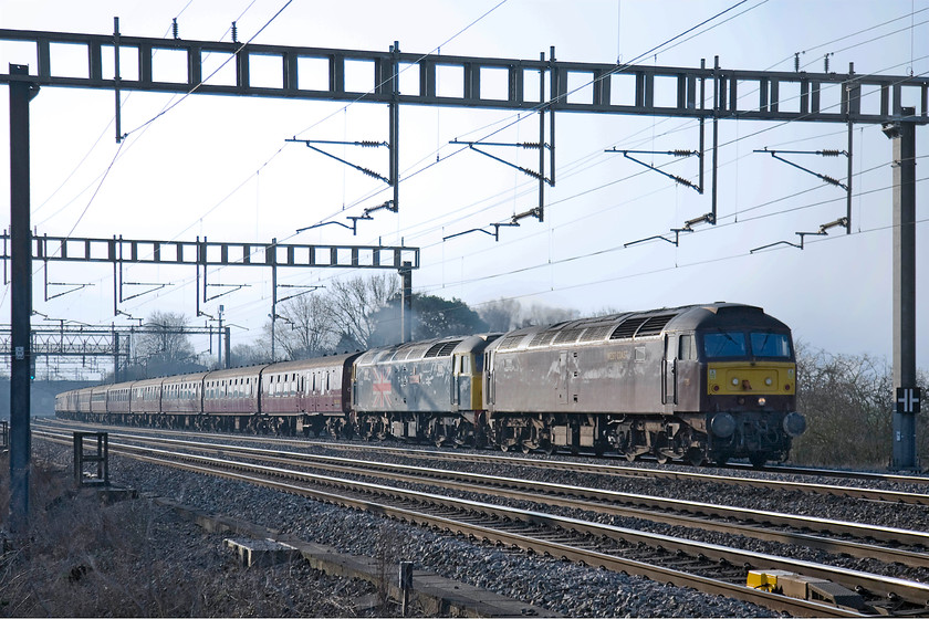 47237 & 47580, outward leg of The Cumbrian Coast Express, 07.10 London Euston-Carlisle (1Z86), Ashton Road bridge 
 The Cumbrian Coast Express, running with the usual 1Z86 headcode is seen passing between Roade and Ashton in Northamptonshire. Unusually, it is being headed by 47237 in its drab WCR livery with 47580 'County of Essex' behind resplendent in its reproduction BR blue. The two class 47s are substituting for the more usual 86259 'Les Ross/Peter Pan' that was unavailable. Further problems were encountered on the day as the train did not take the Cumbrian coast route as planned but travelled via Shap to Carlise. 
 Keywords: 47237 47580 The Cumbrian Coast Express 07.10 London Euston-Carlisle 1Z86 Ashton Road bridge