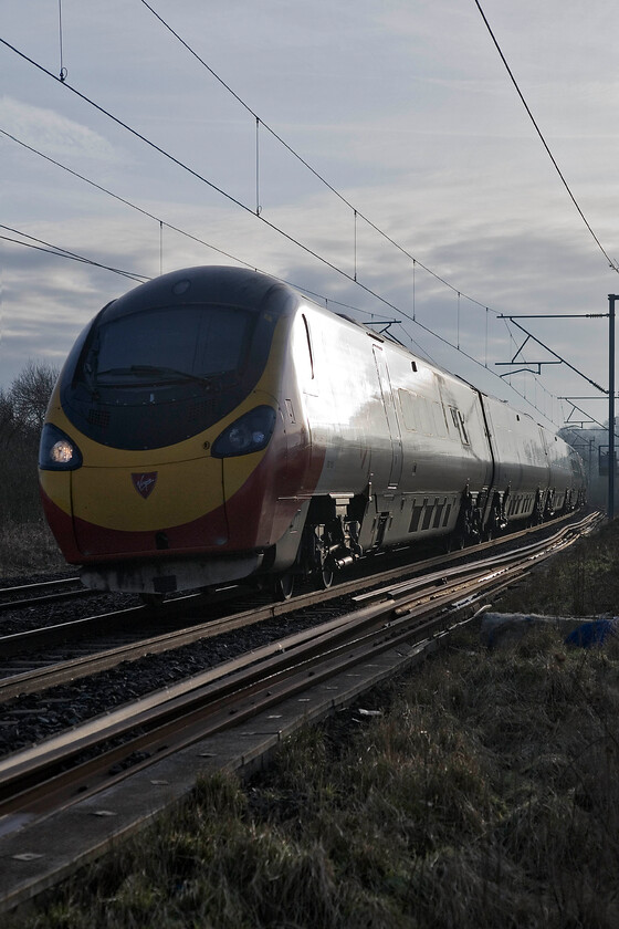 390152, VT 07.20 London Euston-Wolverhampton, Bugbrooke SPO676565 
 390152 makes an impressive sight as it passes near Bugbrooke in Northamptonshire working the 07.20 Euston to Wolverhampton service. The photograph is taken from a secure area where a footpath crosses the line on a footbridge. There are a number of positions that can offer reasonable images around this spot but a little fence climbing and stretching may be required! 
 Keywords: 390152 07.20 London Euston-Wolverhampton Bugbrooke SPO676565 Virgin Pendolino