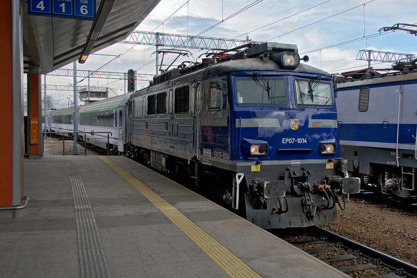 EP07-1014, 05.15 Lublin Glwny-Wroclaw Glwny (IC26104), Krakw Glwny station 
 EP07-1014 brings the 05.15 Lublin to Wroclaw into Krakw Glwny station at some speed. During a dwell time of about fifteen minutes, the locomotive to the right will come on to the back of the train for it to continue its journey to the Polish capital Wroclaw. Looking at a map, this, and a number of other trains on the PKP network, takes some very strange routes. Lublin is a city some distance northeast of Krakw and a relatively short direct distance from Wroclaw. Once it leaves Krakw it will head almost due north some distance to its destination. Never mind though, the joy of travelling in a comfortable compartment on a genuine carriage being hauled by a proper locomotive would trump the circuitous route for me any day! 
 Keywords: EP07-1014 05.15 Lublin Glwny-Wroclaw Glwny IC26104 Krakow Glwny station