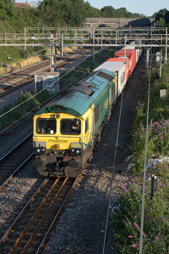 66418, 04.10 Crewe Basford Hall-Felixstowe North (4L89, 1E), site of Roade station 
 With the driver nonchalantly sitting with his arms folded at the controls he brings 66418 'Patriot - In Memory of Fallen Railway Employees' into the morning sunshine at Roade emerging from the depths of the cutting. The Class 66 is leading Freightliner's 4L89 04.10 Crewe Basford Hall to Felixstowe service. 
 Keywords: 66418 04.10 Crewe Basford Hall-Felixstowe North 4L89 site of Roade station Freightliner Patriot - In Memory of Fallen Railway Employees