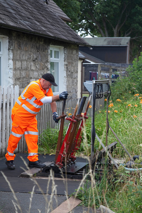 Crossing keeper, operating the ground frame, Burneside SD503954 
 Having closed the crossing gates over the minor road in Burneside village, the crossing keeper operates the ground-frame that will pull off the home signal to allow a train to pass. This is a remarkable survival of Victorian Infrastructure in a sea of digital signalling! I suspect that the cost of manning the crossing will lead to it being automated very soon. 
 Keywords: Crossing keeper operating the ground frame Burneside SD503954