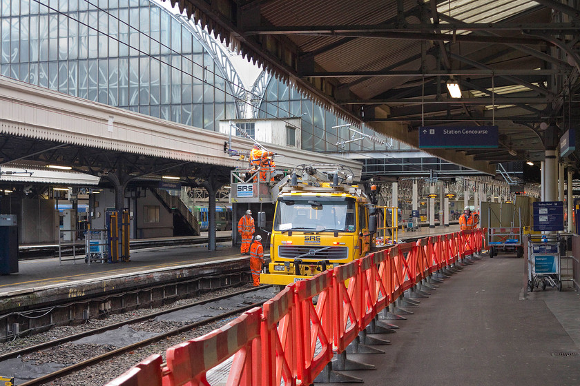 Electrification work being undertaken, London Paddington station 
 In a familiar location at the end of of Paddington's famous platform one, 'the road to the west' as Network Rail contractors work to install the catenary supports. I observed the team for while, and, whilst not wishing to appear critical, they were not working efficiently. There were a number of workers who were simply observing the work and not actually doing anything apart from being on their mobile 'phones. Also, despite the line being completely closed and under occupation, there were three lookouts, is that absolutely necessary but perhaps I'm missing something? 
 Keywords: Electrification work being undertaken London Paddington station