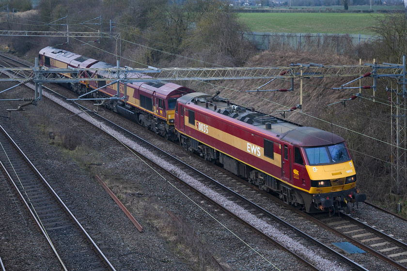 90035, 66133 & 66134, 13.35 Crewe TMD-Wembley LEs, Victoria Bridge 
 A triple headed light engine movement passes Victoria Bridge between Roade and Ashton on the WCML. the trio of 90035, 66133 & 66134 formed the 13.35 from Crewe TMD to Wembley. 
 Keywords: 90035 66133 66134 Crewe TMD-Wembley Light engine Victoria Bridge