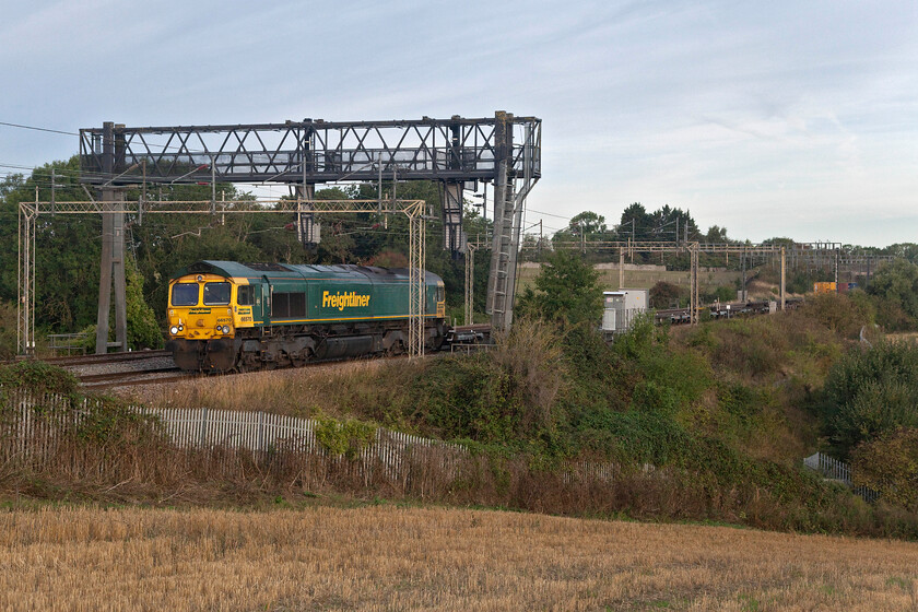 66570, 05.34 DIRFT-Tilbury (4Z61, 9E), between Roade & Ashton 
 The first of two southbound Freightliners within five minutes pass the fields between Roade and Ashton in Northamptonshire. 66570 leads the very late running 4Z61 05.34 Daventry to Tilbury Freightliner. Due to issues further south with up and down trains all having to use the slow lines freight was being held until paths appeared between passenger workings. 4Z61 had been sitting at Northampton for well over an hour before being permitted to continue its journey. However, despite these problems, it still arrived early at its destination due to its stopover in Wembley Yard being all but abandoned! 
 Keywords: 66570 05.34 DIRFT-Tilbury 4Z61 between Roade & Ashton Freightliner