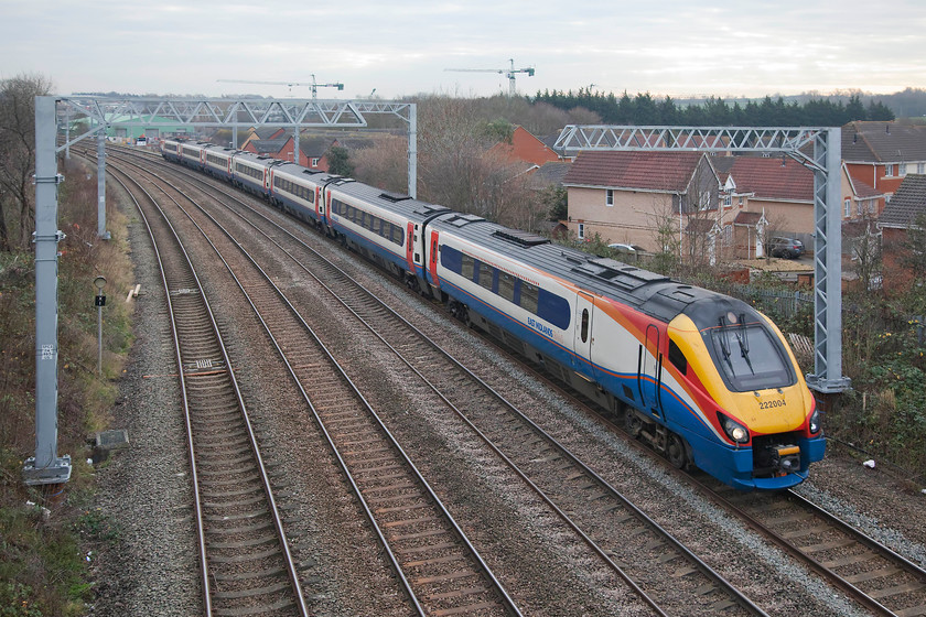 222004, EM 11.02 London St Pancras-Sheffield (1F25, RT), Headlands bridge 
 222004 'Children's Hospital Sheffield' is about to pass under the Headlands bridge just south of Kettering station forming the 1F25 11.02 St. Pancras to Sheffield. Notice above the recently installed electrification masts the two cranes. They do not mark yet more development of Kettering (a process that seems to be inexorable) but are located at McAlpine's plant development site on the edge of the town, a familiar sight to those who pass it on the busy A14 trunk road. 
 Keywords: 222004 11.02 London St Pancras-Sheffield 1F25 Headlands bridge