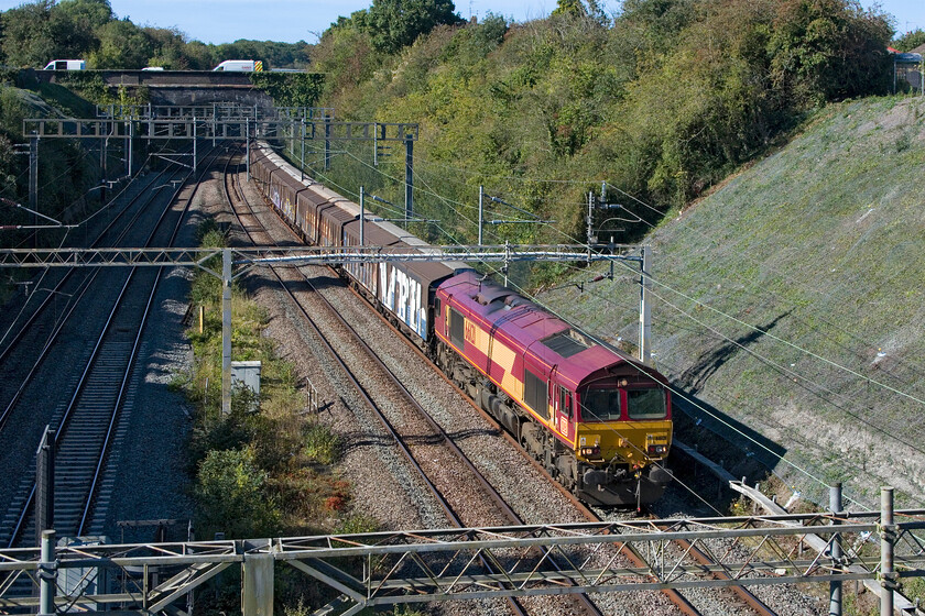 66121, 14.59 DIRFT-Dollands Moor (6O71, 6E), former A508 bridge 
 The empty water train passes Roade at the southern end of the famous cutting led by EWS liveried 66121. On arrival in Kent, the 14.59 Daventy to Dollands Moor will pass through the tunnel to the continent heading south to collect more plastic bottles of mineral water for resale throughout the UK> 
 Keywords: 66121 14.59 DIRFT-Dollands Moor 6O71 former A508 bridge EWS DB Water Train