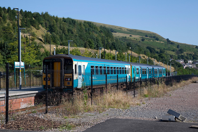 153367, AW 16.37 Ebbw Vale Parkway-Cardiff Central (2B71), Ebbw Vale Parkway station 
 Ebbw Vale Parkway station is situated on the valley floor at the head of the valley. The relative flat bottom was occupied by the huge steel works complex. Its fortunes waxed and wained as went through various changes of owners with it finally closing in 2002. The land has been extensively redeveloped but the area remains a little bare in places with work still on-going. As part of the plans the railway that was used extensively by the coal and steel industries was re-opened to passengers in 2008. 153367 and a class 150 leave Ebbw Vale Parkway station with the 16.37 to Cardiff Central. 
 Keywords: 153367 16.37 Ebbw Vale Parkway-Cardiff Central 2B71 Ebbw Vale Parkway station