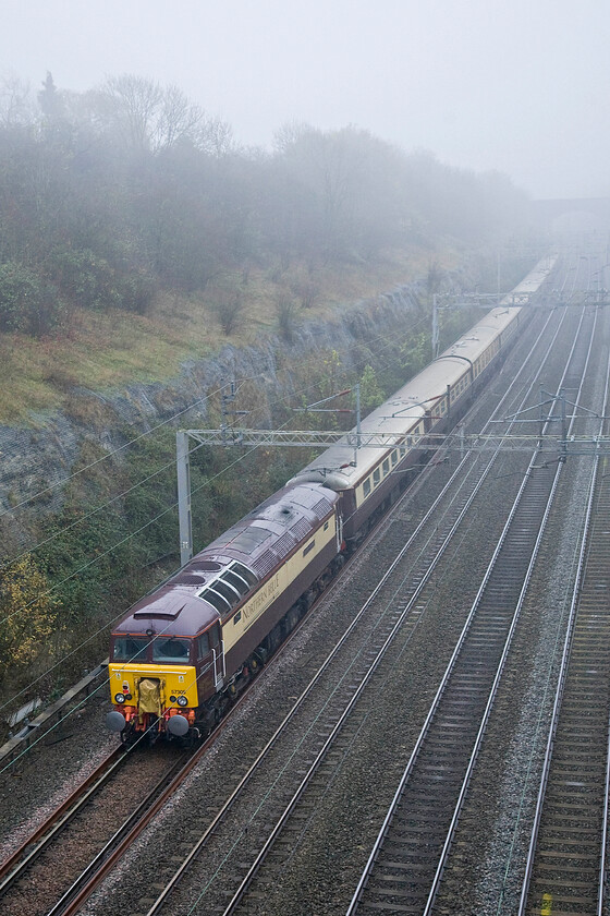 57307, outward leg of The Northern Belle, 06.39 Liverpool Lime Street-London Euston (1Z26), Roade cutting 
 57307 'Northern Princess' brings up the rear of Northern Belle's 06.39 Liverpool Lime Street to Euston 1Z26 charter. The converted Class 47 is instantly recognisable as one of Virgin's former Thunderbirds by virtue of the emergency Delinier coupling covered up by the yellow bagging. Out of sight in the fog 57312 'Solway Princess' leads the train that was carrying passengers who could enjoy an afternoon in London upon their arrival at Euston. 
 Keywords: 57307 The Northern Belle 06.39 Liverpool Lime Street-London Euston 1Z26 Roade cutting Northern Princess DRS