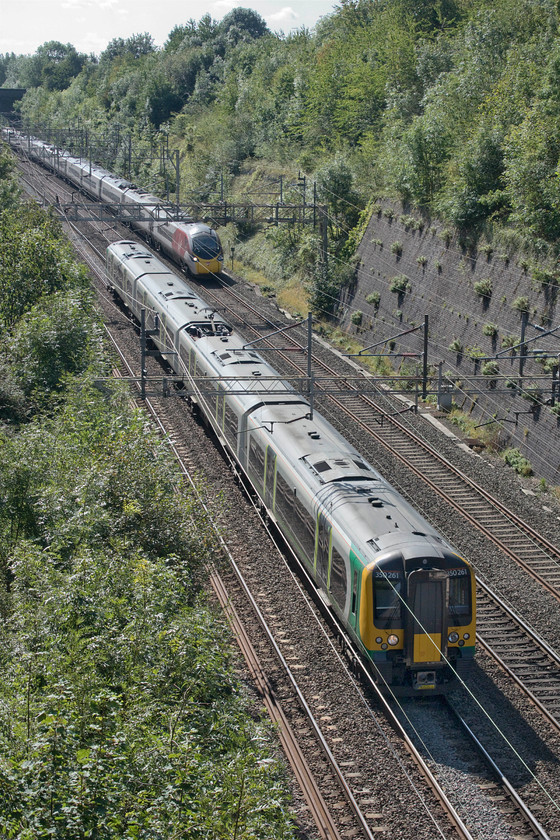 350261, LN 09.54 London Euston-Northampton (2N09, RT) & 390117, VT 10.20 London Euston-Manchester Piccadilly (1H18, 7L), Roade cutting 
 As 350261 passes through Roade cutting with the 09.54 Euston to Northampton it is approaching the end of what will be its seventy mile journey from the capital. Meanwhile, 390117 Blue Peter is approximately forty minutes into its journey, the 10.20 to Manchester Piccadilly. Things were running well on this day as both trains arrived right time at their destinations. 
 Keywords: 350261 09.54 London Euston-Northampton 2N09 390117 10.20 London Euston-Manchester Piccadilly 1H18 Roade cutting