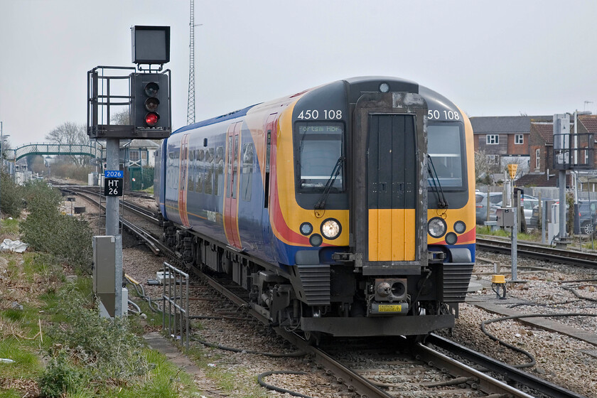 450108, SW 12.30 London Waterloo-Portsmouth Harbour, Havant station 
 Crossing over from the down mainline to the bi-directional platform one 450108 arrives at Havant working the 12.30 Waterloo to Portsmouth Harbour service. Just behind the rear of the train is the level crossing and footbridge on New Lane and the redundant, boarded up and ivy-clad signal box. 
 Keywords: 450108 12.30 London Waterloo-Portsmouth Harbour Havant station SouthWest Trains Desiro