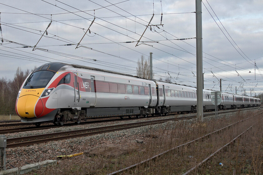 801204, GR 08.30 York-London King's Cross (1G02, 10L), Tallington Dowmac 
 I make no apology for repeating my assertion that I believe that the LNER Azuma fleet is by far the smartest and most purposeful of the A-Train family of trains. Seeing one at close quarters in full flight on the ECML is an impressive sight in anybody's books - tin hat anybody! This photograph of 801204 working the 08.30 York to King's Cross non-stop service amply illustrates my point. The train is seen passing Tallington adjacent to the Dowmac concrete plant just north of the level crossing. 
 Keywords: 801204 08.30 York-London King's Cross 1G02 Tallington Dowmac. LNER Azuma