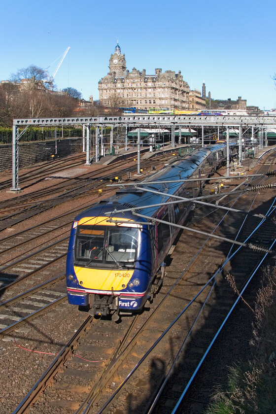 170420, SR 16.33 Edinburgh Waverley-Perth, Edinburgh Waverley station from The Mound 
 170420 rattles away from Edinburgh Waverley station working the 16.33 service to Perth. To take this photograph I am a little packed in between some fencing and a hedge standing on a dwarf wall training the camera over the railings utilising the fold-out screen. 
 Keywords: 170420 16.33 Edinburgh Waverley-Perth Edinburgh Waverley station from The Mound First Group ScotRail